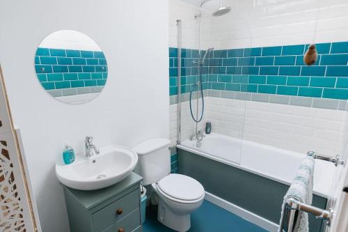 a blue and white bathroom with a toilet and a sink at LITTLE BLUE HOUSE - Cottage with Seaview near the Lake District National Park in St Bees