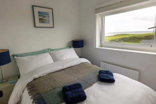 a bedroom with a bed with two blue towels on it at LITTLE BLUE HOUSE - Cottage with Seaview near the Lake District National Park in St Bees