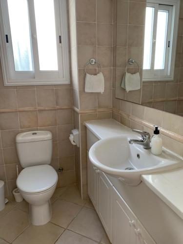 ein Badezimmer mit Toilette und Waschbecken in der Unterkunft Villa Celine in Klorakas