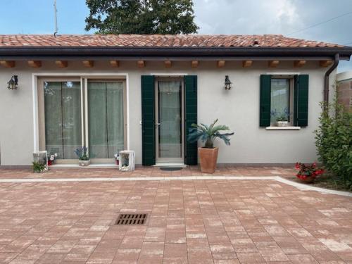 a small white house with a potted plant in front of it at LA CASETTA - chalet in campagna in Legnaro