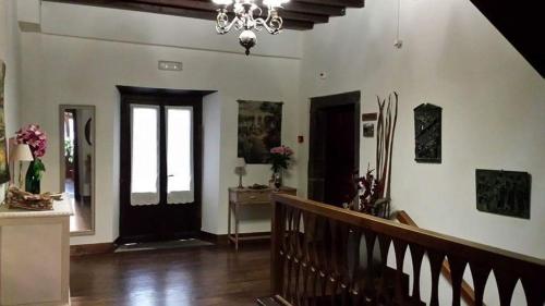 a living room with a staircase and a chandelier at Hotel Rural Palacio de Galceran in Sotiello