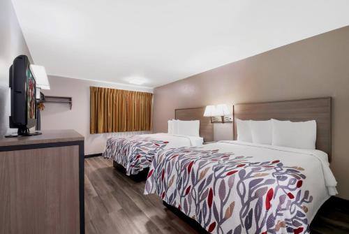 a hotel room with two beds and a flat screen tv at Red Roof Inn Chattanooga - Lookout Mountain in Chattanooga