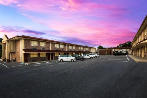 a parking lot with cars parked in front of a building at Red Roof Inn Chattanooga - Lookout Mountain in Chattanooga