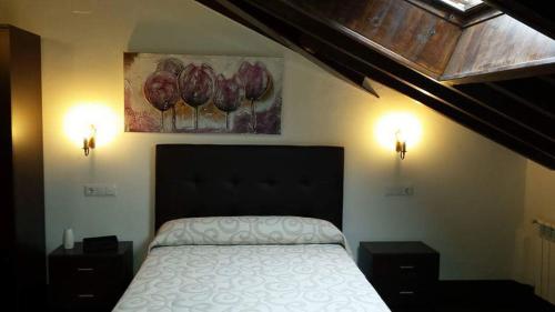 a bedroom with a bed with two night stands and two lights at Hotel Rural Palacio de Galceran in Sotiello