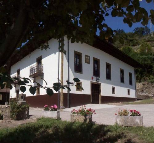 a white building with a cross on the side of it at Hotel Rural Palacio de Galceran in Sotiello