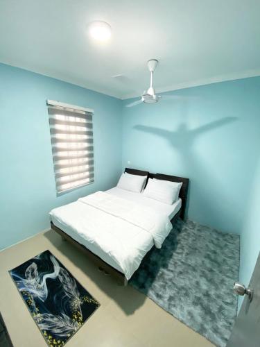 a bedroom with a bed with a blue wall at Baiduri Homestay in Kota Tinggi