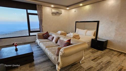 a living room with a couch and a bed at Al Namteh Lodge in ‘Ābil