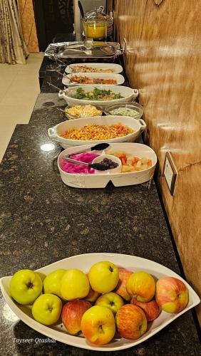 a row of trays of food on a counter at Al Namteh Lodge in ‘Ābil