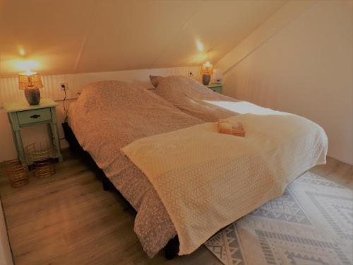 ein Schlafzimmer mit einem großen Bett mit zwei Lampen in der Unterkunft Gezellige vakantiewoning aan het water in Ewijk - recreational only no workers in Ewijk