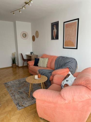 a living room with two couches and a table at City Garden Apartment in Plovdiv