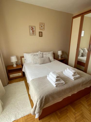 a bedroom with a bed with towels on it at City Garden Apartment in Plovdiv