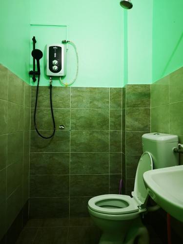 La salle de bains est pourvue de toilettes et d'une douche. dans l'établissement Afwan homestay klebang melaka, à Malacca