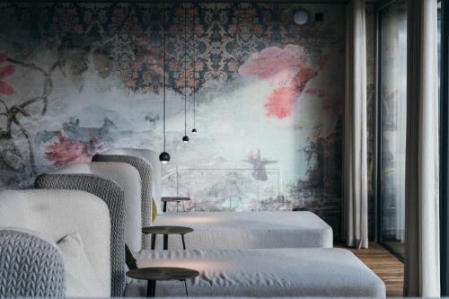 a row of beds in a room with a wallpaper at Aparthotel My Daum in Nova Ponente