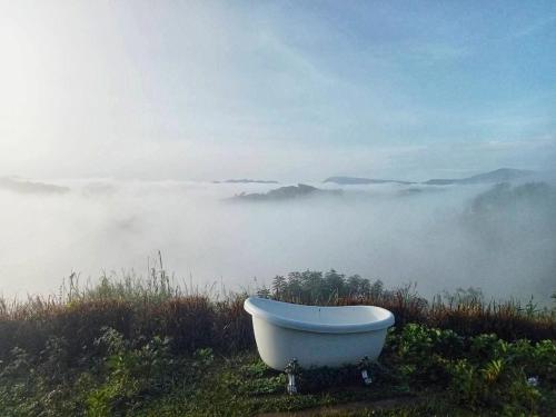 a bath tub sitting on top of a hill in the fog at Papa Garden Khaokho in Khao Kho