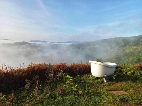 a bath tub sitting on the side of a hill with fog at Papa Garden Khaokho in Khao Kho