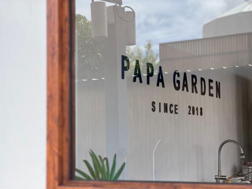 a reflection of a papa garden sign in a window at Papa Garden Khaokho in Khao Kho
