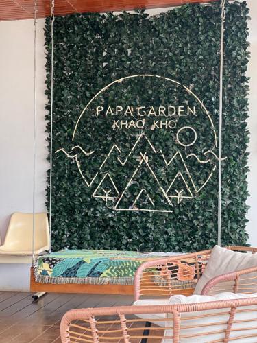 a wall covered in ivy with a chalkboard on it at Papa Garden Khaokho in Khao Kho