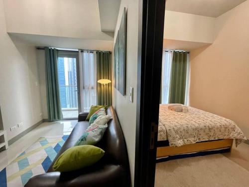 ein Wohnzimmer mit einem Sofa und einem Bett in der Unterkunft Tropical 1BR Uptown Parksuites BGC, 200mbps Smart TV in Manila