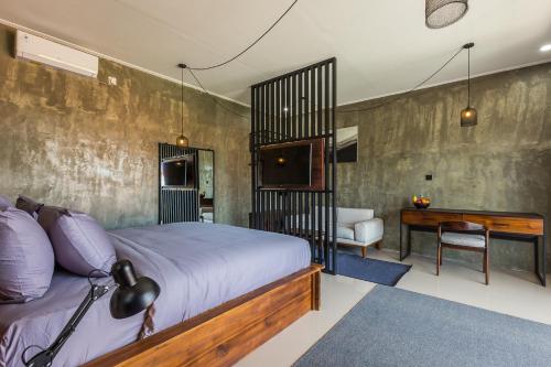 a bedroom with a bed and a desk in a room at Modern Industrial Apartment-Umalas w Wifi and pool in Canggu