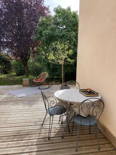 un patio avec une table et des chaises sur une terrasse dans l'établissement MAISON 4 chambres 12 pers à 2,8KM DU CIRCUIT et proche BOULERIES JUMP, au Mans