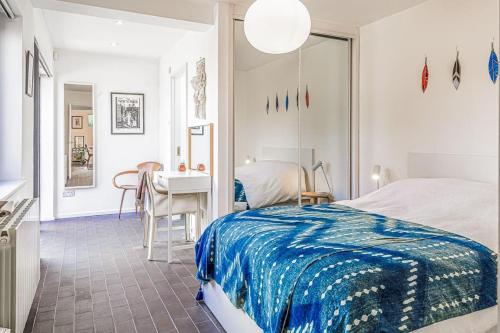 1 dormitorio con cama, mesa y escritorio en Gorgeous 1BD Balearic-style home with Gardens en Cheltenham