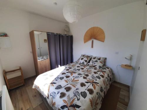 une chambre avec un lit avec une couette dessus dans l'établissement Mon Alouette - Gîte & Bien-Être, aux Herbiers