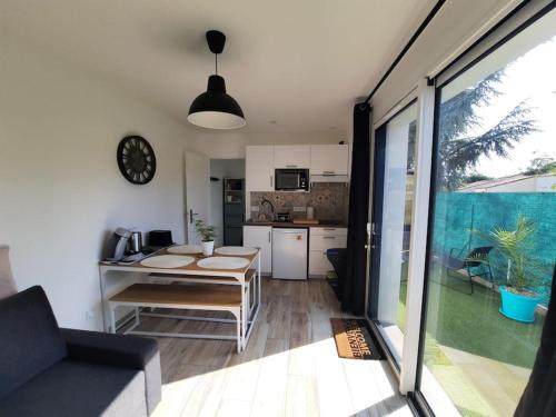 Il comprend une cuisine et un salon avec une table et une horloge. dans l'établissement Mon Alouette - Gîte & Bien-Être, aux Herbiers