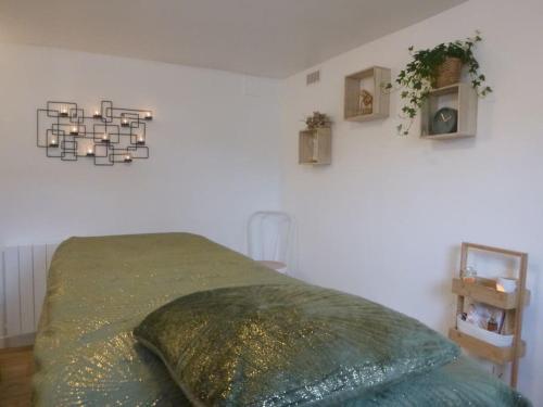 1 dormitorio con 1 cama con manta verde en Mon Alouette - Gîte & Bien-Être, en Les Herbiers