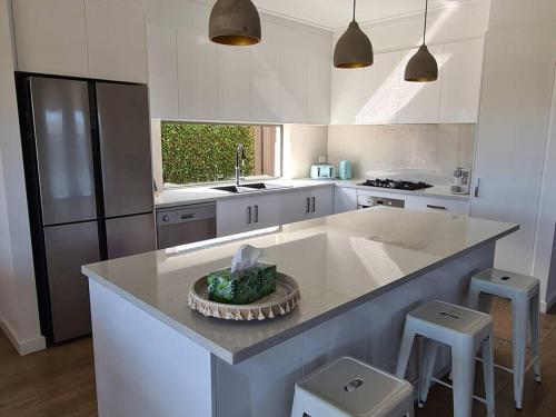 a kitchen with a large island with a counter top at Coastal Palms - relax by the golf course in Normanville