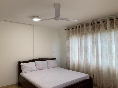 um quarto com uma cama e uma ventoinha de tecto em One Cozy Bedroom in a shared apartment em Kumasi