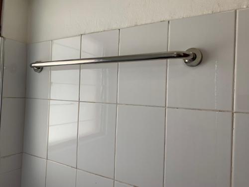 - un rideau de douche dans la salle de bains revêtue de carrelage blanc dans l'établissement One Cozy Bedroom in a shared apartment, à Kumasi