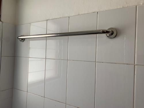 a shower curtain in a bathroom with white tiles at One Cozy Bedroom in a shared apartment in Kumasi