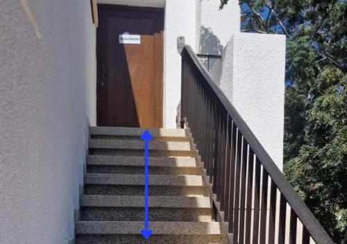 a stairway with a blue arrow in front of a door at Adamandri Lodge - Prime Location in Ayia Napa