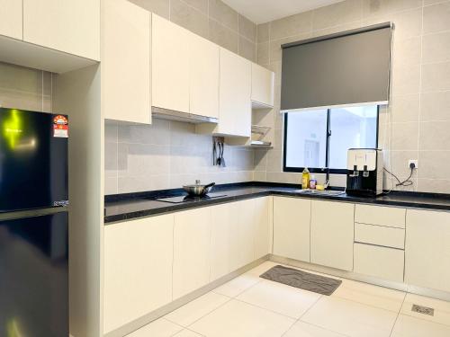 a kitchen with white cabinets and a window at Twin Tower Residence by Nest Home【5 mins walk to CIQ】 in Johor Bahru