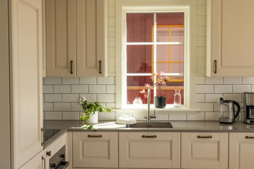 a white kitchen with a sink and a window at Hotel Strana in Hälleviksstrand