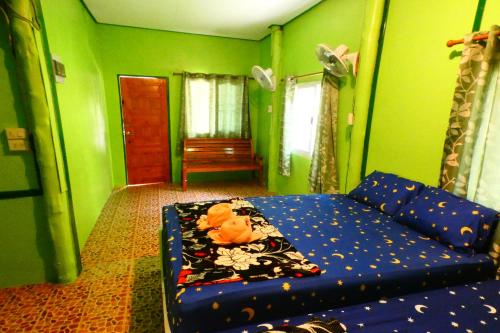 a living room with a blue couch and green walls at Ao Yai Homestay in Ban Ao Yai