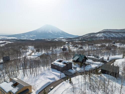 an aerial view of a resort in the snow with a mountain at Meikeikyo Hanazono in Kutchan