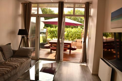 een woonkamer met een bank en een tafel met een paraplu bij kerloch gwen in Combrit