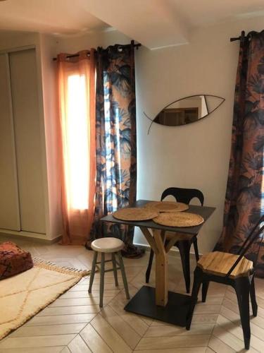 une pièce avec une table, des chaises et une fenêtre dans l'établissement Le Cocon-Centre Ville-Canal Royal, à Sète