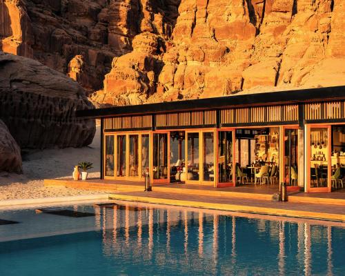 a resort with a pool in front of a mountain at Our Habitas AlUla in AlUla