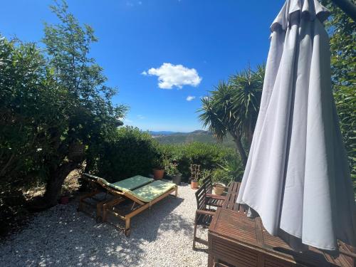 une terrasse avec un parasol blanc, une table et des chaises dans l'établissement LA MAISON D'AUREL, à La Croix-Valmer