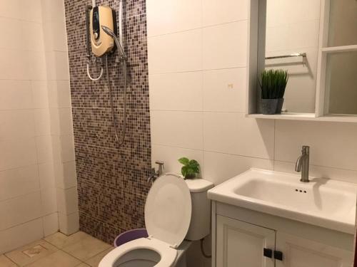 La salle de bains est pourvue de toilettes, d'un lavabo et d'une douche. dans l'établissement Homestay Ruma Melaka, à Malacca