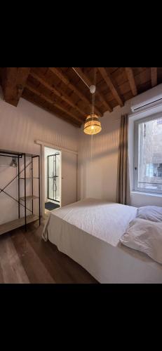 a bedroom with a white bed and a window at Appartement centre historique in Arles