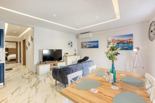 a dining room and living room with a table and a couch at Bluebell Apartment in Sliema in Sliema