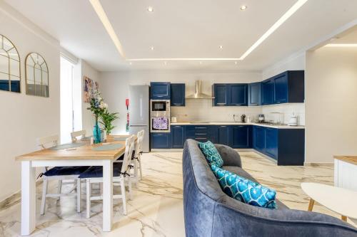 a kitchen and dining room with blue cabinets and a table at Bluebell Apartment in Sliema in Sliema