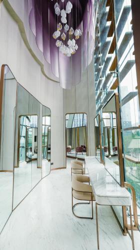 a dining room with a glass table and chairs at MGM Qingdao in Qingdao
