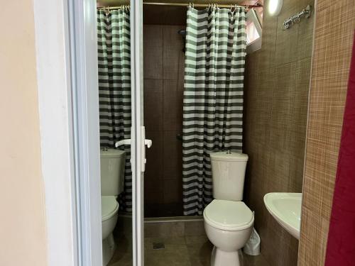 a bathroom with a toilet and a sink at Gold Guest House in Gonio