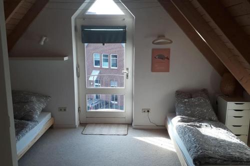 a room with two beds and a door with a window at Nordhörnchen! Sehr zentral, trotzdem ruhig! in Nordhorn