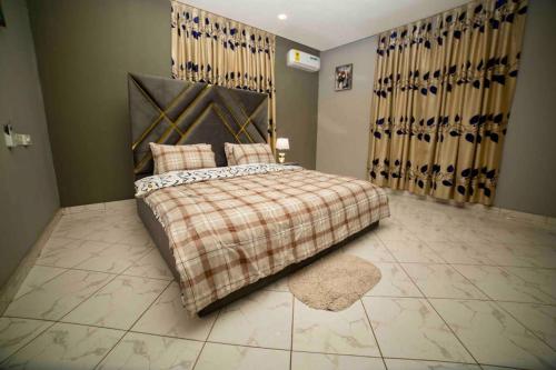 a bedroom with a bed with a blanket and a rug at 3 bedrooms, Entire Flat, Amasaman - Accra in Amasaman