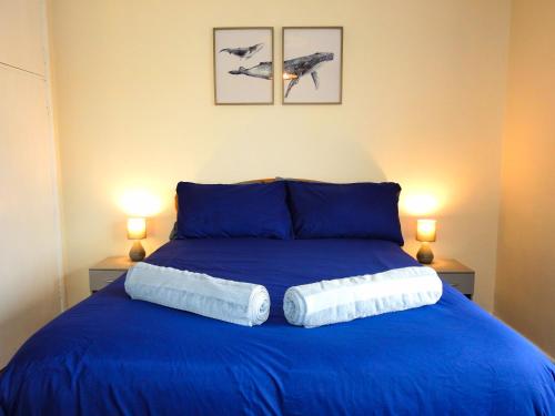 una camera da letto con un letto blu con due asciugamani di Butland House a Pembrokeshire